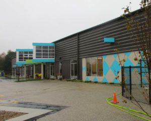 Blue and gray front of the Charlie Brown Preschool & Child Care Centers in Mason City, IA on a rainy day.